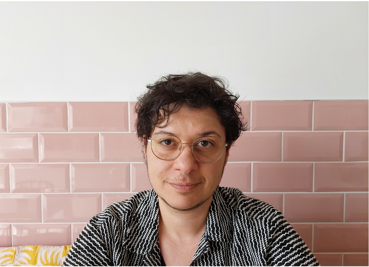 Nassos Theodor profile picture showing a trans therapist against a pink tile background.